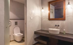 a bathroom with a toilet and a sink and a mirror at 976 Panangad in Cochin