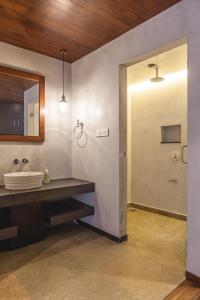 a bathroom with a sink and a mirror and a door at 976 Panangad in Cochin