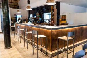 a bar with a row of bar stools at Complejo Rural Rio Tus in Yeste