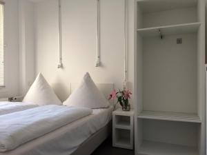 a bedroom with two beds with white sheets and flowers at Apartment&Rooms near Brandenburg Gate in Berlin