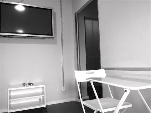 a room with a table and a tv on the wall at Apartment&Rooms near Brandenburg Gate in Berlin