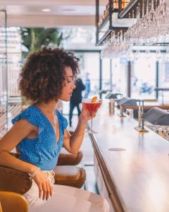 a woman sitting at a bar holding a drink at Seventy Barcelona in Barcelona