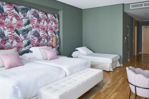 two beds in a room with a mural on the wall at Vincci Selección Posada del Patio in Málaga