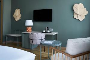 a room with a bed and a table and a tv at Vincci Selección Posada del Patio in Málaga