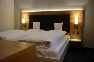 A bed or beds in a room at Die Krone am Fluss - Landhotel Sindringen