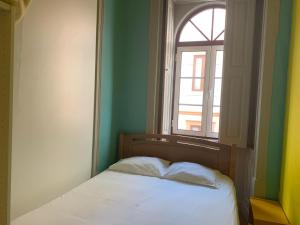 uma cama num quarto com uma janela em Meeting Hostel em Figueira da Foz