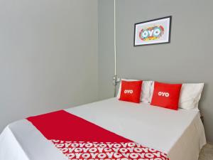 a bedroom with a bed with two red pillows at OYO Hotel Castro Alves, São Paulo in Sao Paulo