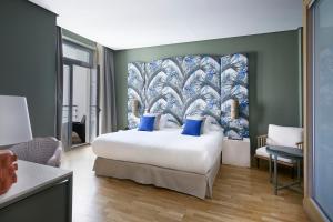 a bedroom with a large bed with blue pillows at Vincci Selección Posada del Patio in Málaga