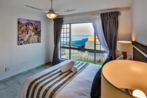 a bedroom with a bed with a view of the ocean at 302 Kenwyn on Sea- Luxury Beachfront Getaway in Ballito