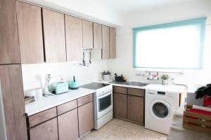 a kitchen with a sink and a washing machine at Glabur Stays - The Cozy 2 BDR - Nicosia City, Free Parking & Wifi, Welcomes You!!! in Nicosia