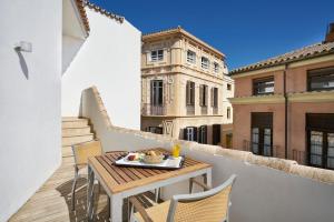 a table and chairs on a balcony with a building at Vincci Selección Posada del Patio in Málaga