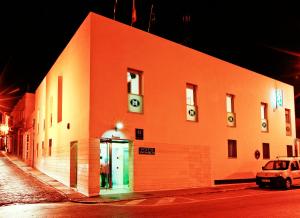 Un bâtiment orange avec une voiture garée devant. dans l'établissement Hostal San Marcos, à San Fernando