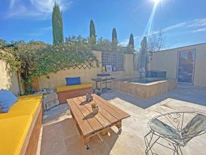 eine Terrasse mit Tisch und Stühlen und einem Pool in der Unterkunft La maison des Fontanille in Saint-Rémy-de-Provence