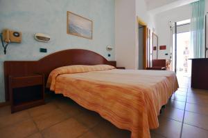 sypialnia z dużym łóżkiem i pomarańczowym kocem w obiekcie Hotel Europa w mieście Misano Adriatico