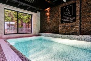 a large swimming pool in a room with a window at WILLIAM Congress&Wellness Mountain HOTEL **** in Deštné v Orlických horách