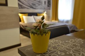 un vase jaune avec des fleurs assis sur une table dans l'établissement White & Black Home, à Saint-Pétersbourg