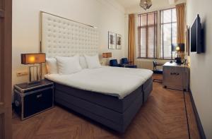 a bedroom with a large bed with a large headboard at Hotel New York by WestCord in Rotterdam