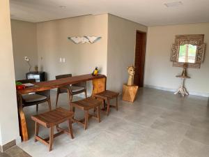 a dining room with a wooden table and chairs at Pousada Recanto in Fernando de Noronha