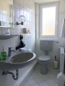 a white bathroom with a sink and a toilet at Haus Luisenhof in Mölln