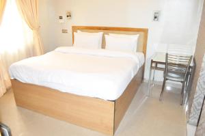 Rúm í herbergi á Triple Tee Hotel