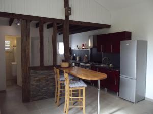 Il comprend une cuisine équipée d'une table en bois et d'un réfrigérateur. dans l'établissement Petite maison, à Gabarret
