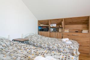 a bedroom with two beds and a wooden wall at Sweet Alvani in Akhmety