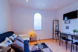 ein Wohnzimmer mit einem Sofa und einem Tisch in der Unterkunft Brand New Studio, Sea View, AirCon, Wifi in Roquebrune-Cap-Martin