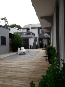 eine Holzterrasse in einem Hof mit einem Haus in der Unterkunft Studio du 104 in Saint-Jean-de-Monts