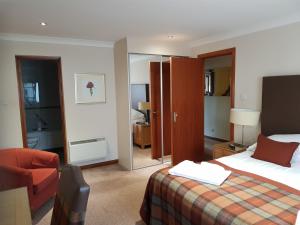 a hotel room with a bed and a desk at Macdonald Plas Talgarth Resort in Pennal