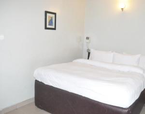 Rúm í herbergi á Triple Tee Hotel