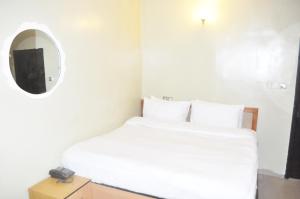 Rúm í herbergi á Triple Tee Hotel