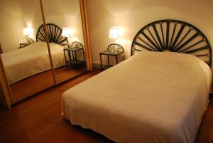 a hotel room with two beds and two mirrors at Villa à 100 m de Tarbes sud in Laloubère