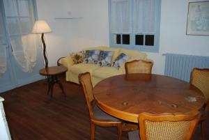 uma sala de estar com uma mesa e um sofá em Villa à 100 m de Tarbes sud em Laloubère
