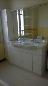 a bathroom with two sinks and a large mirror at Villa à 100 m de Tarbes sud in Laloubère