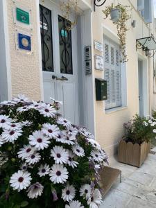 un montón de flores blancas delante de una puerta en Acro&Polis, en Atenas