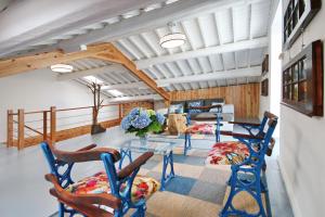 a living room with blue chairs and a glass table at A Casinha Azul in Vila Franca do Campo