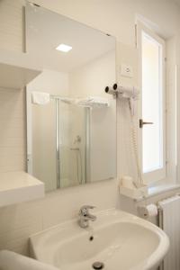 y baño blanco con lavabo y ducha. en Agriturismo La Solagna, en Montebello di Bertona