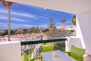 a balcony with green chairs and a view of the city at Apartamentos Torrenueva Park in La Cala de Mijas