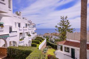 a row of white buildings with the ocean in the background at Torrenueva Park Apartments in La Cala de Mijas