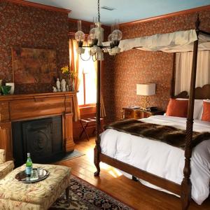 a bedroom with a canopy bed and a fireplace at Elmwood 1820 Bed & Breakfast Inn in Washington