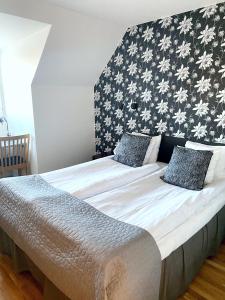 a bedroom with a large bed with a black and white wall at Hotel Carlshamn in Karlshamn