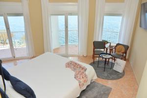 a bedroom with a bed and views of the ocean at Rallye Hotel in L'Escala