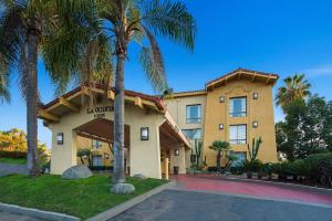 a hotel with palm trees in front of a building at La Quinta Inn by Wyndham San Diego - Miramar in Sabre Springs