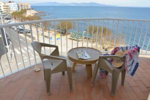 a balcony with a table and chairs and the ocean at Rallye Hotel in L'Escala