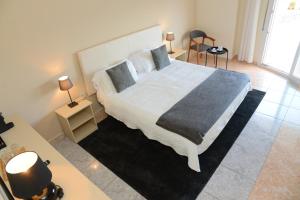 a bedroom with a large bed and two lamps and a table at Rallye Hotel in L'Escala