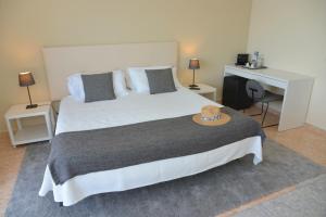 a bedroom with a large bed with a hat on it at Rallye Hotel in L'Escala