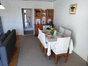 a dining room with a table and white chairs at Apartman Mimi in Klenovica