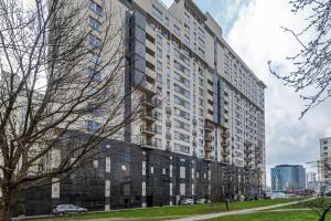 un grand bâtiment dans une ville avec un arbre dans l'établissement Bukowińska 22 by Homeprime, à Varsovie