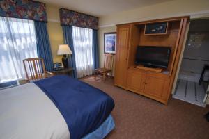 a hotel room with a bed and a flat screen tv at El Tovar - Inside the Park in Grand Canyon Village
