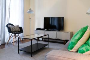 a living room with a tv and a couch and a table at Lisbon Apartment near Marquês Pombal square in Lisbon